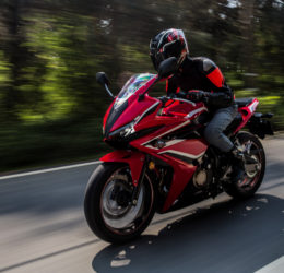 A red motorcycle speeds along a highway.